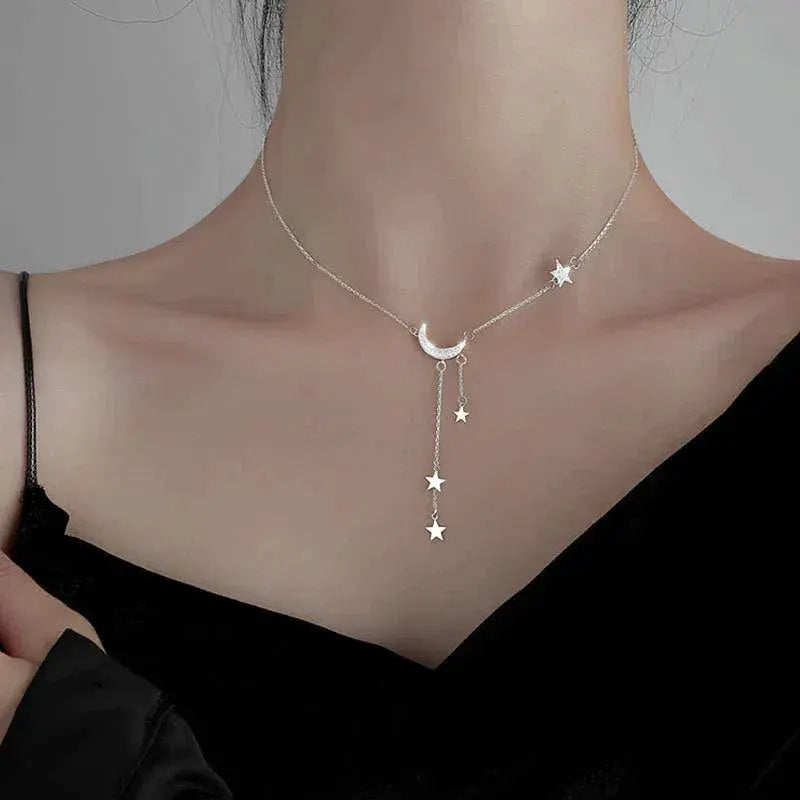 Elegante collar de plata con luna y estrellas.